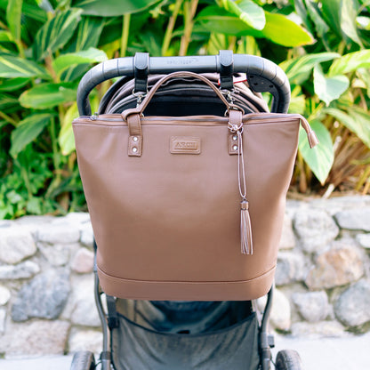 Brown nappy bag attached to pram using pram clips